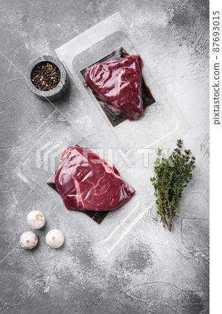 Pack with fresh rump beef steak, on gray stone table background, top view flat lay Pack with fresh rump beef steak, on gray stone table background, top view flat lay 87693015