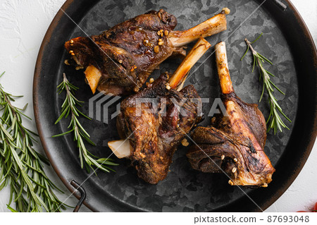 Baked lamb shank meat, on white stone table background, top view flat lay Baked lamb shank meat, on white stone table background, top view flat lay 87693048