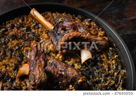 Braised Lamb Shanks with Sauce and Herbs, on old dark wooden table background Braised Lamb Shanks with Sauce and Herbs, on old dark wooden table background 87693050