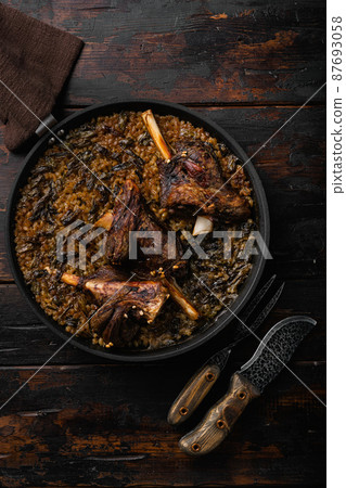 Baked lamb shank meat, on old dark wooden table background, top view flat lay Baked lamb shank meat, on old dark wooden table background, top view flat lay 87693058