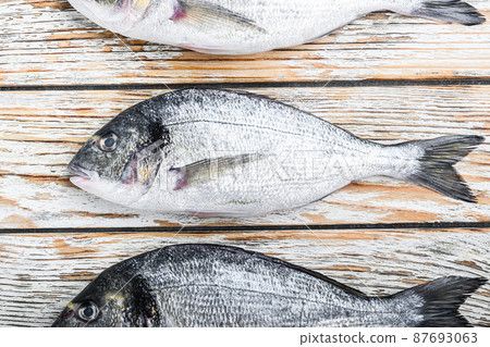 Set of raw whole dorado or Gilt head bream fish over white wood table top view 87693063