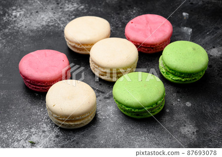 Colorful french macarons, on black dark stone table background Colorful french macarons, on black dark stone table background 87693078