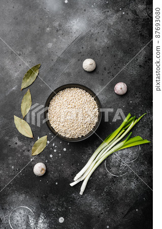 Pearl barley uncooked, on black dark stone table background, top view flat lay, with copy space for text Pearl barley uncooked, on black dark stone table background, top view flat lay, with copy space for text 87693080