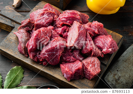 Fresh raw beef cubes with sweet bell pepper, on old dark wooden table Fresh raw beef cubes with sweet bell pepper, on old dark wooden table 87693113
