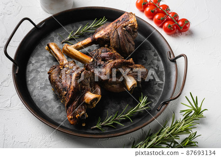 Baked lamb shank with barley and ale, on white stone table background Baked lamb shank with barley and ale, on white stone table background 87693134