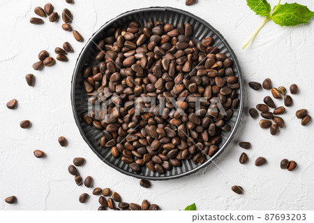 Pine nuts, on white stone table background, top view flat lay Pine nuts, on white stone table background, top view flat lay 87693203