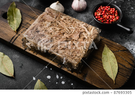 Jellied meat, on black dark stone table background Jellied meat, on black dark stone table background 87693305
