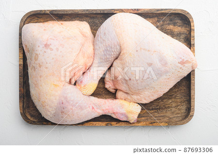 Chicken brow and drumstick with skin, on wooden tray, on white stone background, top view flat lay Chicken brow and drumstick with skin, on wooden tray, on white stone background, top view flat lay 87693306