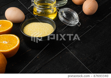 Polenta cake ingredients, with eggs and honey, on black wooden table background, with copy space for text 87693340