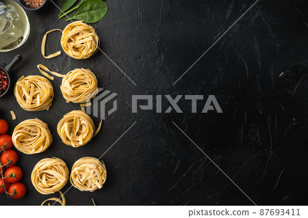 Fettuccine Tagliatelle pasta Italian food ingredients, on black stone background, top view flat lay, with copy space for text 87693411