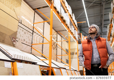 buyers a man in a hardware store chooses porcelain stoneware and ceramic tiles for finishing his buyers a man in a hardware store chooses porcelain stoneware and ceramic tiles for finishing his 87693977