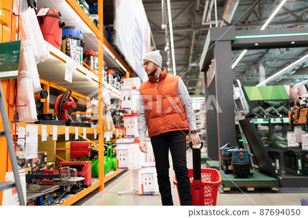a man in a hardware store does not choose an air compressor and gas generator 87694050