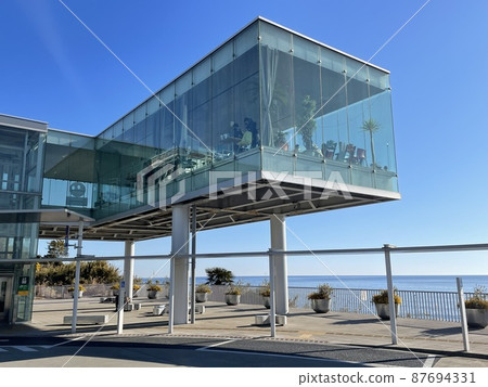 Glass-enclosed cafe / coffee shop with a view of the sea Glass-enclosed cafe / coffee shop with a view of the sea 87694331