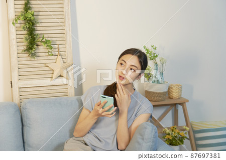 女性智能手機思考客廳之夜 87697381