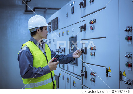 Engineer checking and inspecting at MDB panel .he working with electric switchboard to check range of voltage working in Main Distribution Boards factory. 87697786