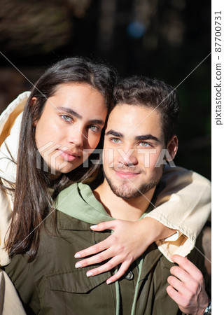 Portrait of young loving couple hugging in forest Portrait of young loving couple hugging in forest 87700731