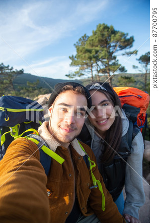 Pleased couple of hikers taking selfie Pleased couple of hikers taking selfie 87700795