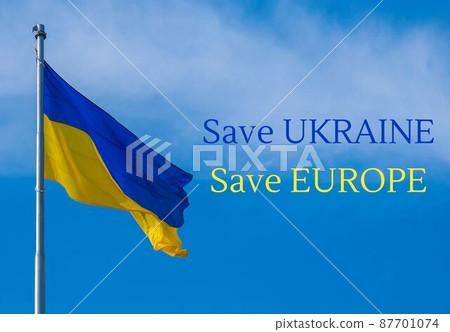 SAVE UKRAINE SAVE EUROPE text on Ukrainian national flag flutters in the wind against the blue sky. National symbol of ukrainian people - blue and yellow. No war. War Protest against Russian invasion 87701074