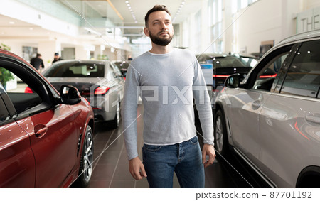 the buyer examines the range of new cars in the dealer showroom 87701192