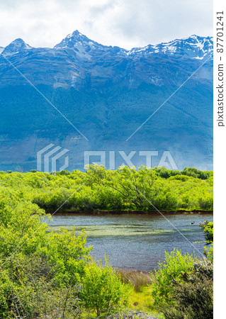 The lagoon seen from the Glenokee lagoon track in the Otago region of New Zealand and the mountains behind it 87701241