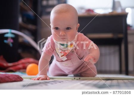 six months old caucasian baby on the floor with a toy 87701808