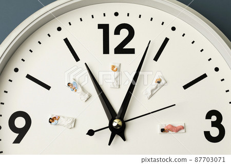 miniature people sleeping on the clock 87703071