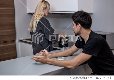 Man and woman are arguing at home. Angry woman is yelling at husband, ignoring 87704251