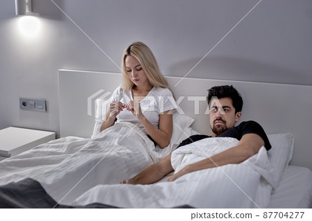 Furious Caucasian Woman And Man During Argue At Home, Sitting On Bed Not Talking Furious Caucasian Woman And Man During Argue At Home, Sitting On Bed Not Talking 87704277