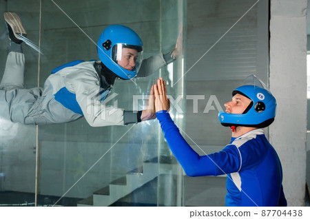 A man trains a woman as an astronaut. Classes on flying in a wind tunnel. A man trains a woman as an astronaut. Classes on flying in a wind tunnel. 87704438