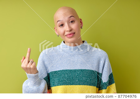 hairless woman wearing casual shirt over green isolated background Showing middle finger 87704976