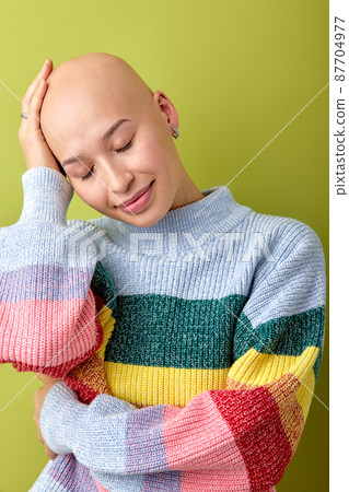 Portrait of lovely caucasian bald woman in bright colorful shirt touching head 87704977