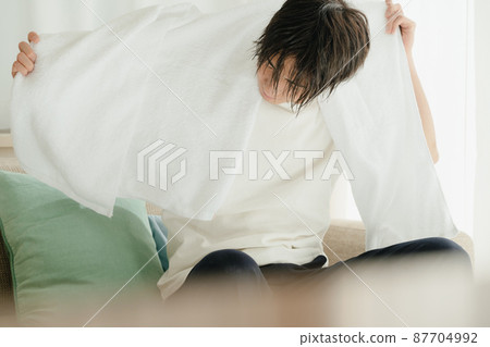 Young man drying wet hair with a towel 87704992