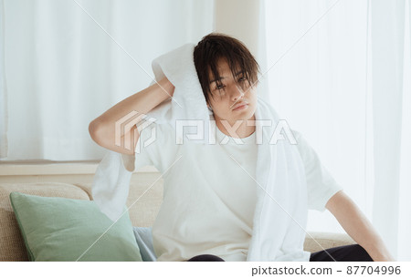 Young man drying wet hair with a towel 87704996