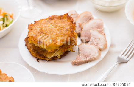 Potato pancakes with meat on white plate 87705035
