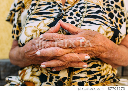 The wrinkled hands of a old woman 87705273