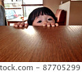 Girl peeking from under the desk 87705299