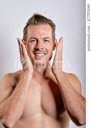 Close-up portrait of excited caucasian guy with wet sexy body posing, touching face Close-up portrait of excited caucasian guy with wet sexy body posing, touching face 87705846