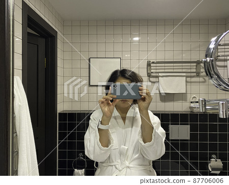 Girl taking a photo in the bathroom. Modern bathroom interior. 87706006