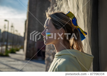 Ukrainian woman with a flag on the cheek 87706334