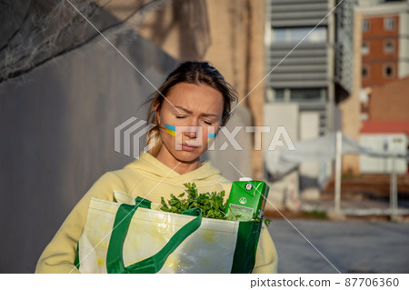 Ukrainian woman with a bag of groceries 87706360