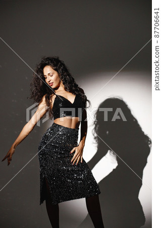 Portrait of caucasian woman salsa dancer under a projector's light Portrait of caucasian woman salsa dancer under a projector's light 87706641