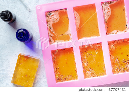 Soap making at home. Liquid glycerin with natural additives poured into mold Soap making at home. Liquid glycerin with natural additives poured into mold 87707481