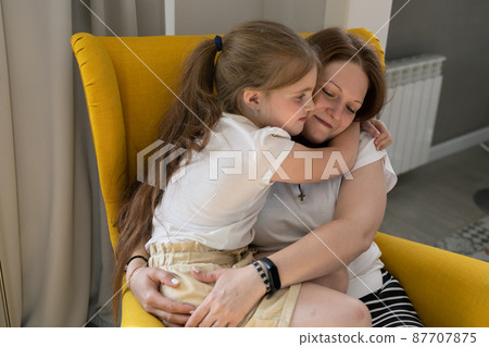 Happy loving family. Mother and her daughter child girl hugging at home - mothers day concept Happy loving family. Mother and her daughter child girl hugging at home - mothers day concept 87707875