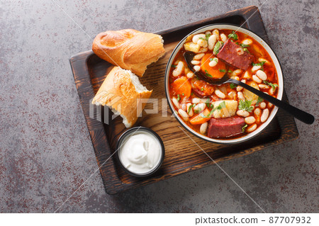 Hungarian goulash soup with beans, meat and vegetables close-up in a bowl. horizontal top view 87707932