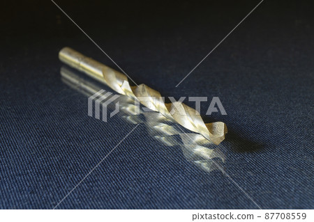 Drill on metal on glass table on black background 87708559
