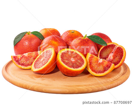 sicilian blood oranges slices on a wooden cutting board isolated on white. 87708697