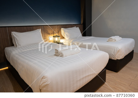 Twin comfortable bed in hotel bedroom. Conceptual shot of a place for someone to stay, live, or work temporary. Twin comfortable bed in hotel bedroom. Conceptual shot of a place for someone to stay, live, or work temporary. 87710360