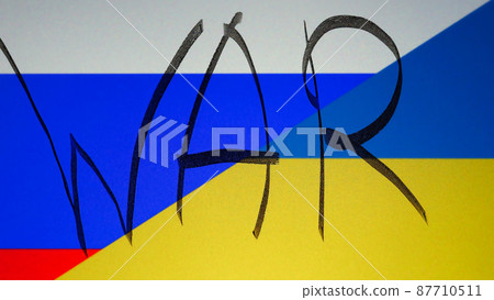 Closeup shot of the Ukrainian and the Russian flag with WAR written on it. 87710511