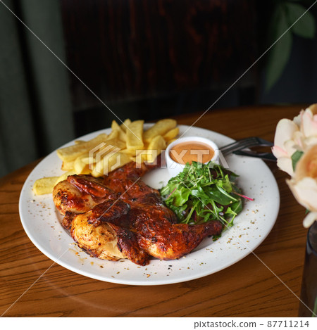 fried chicken tobacco with french fries and tomato sauce on a dark background. top view 87711214