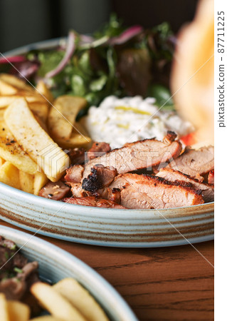 Greek Gyros with chicken or veal, with tzatziki on a dark background Greek Gyros with chicken or veal, with tzatziki on a dark background 87711225